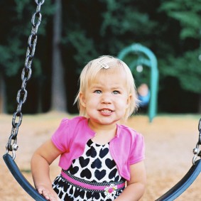 Little girl on the big girl swing